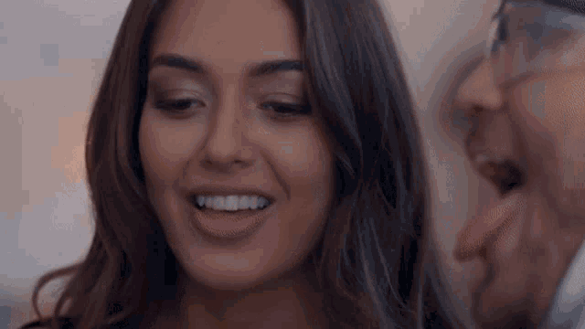 a man and a woman are smiling at each other and the woman is wearing glasses
