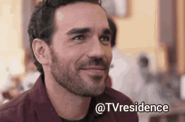 a man with a beard is smiling and looking at the camera with a caption that says ' @tvresidence ' .