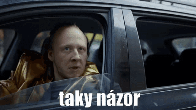 a man is sitting in a car with the word taky nazor written on the side