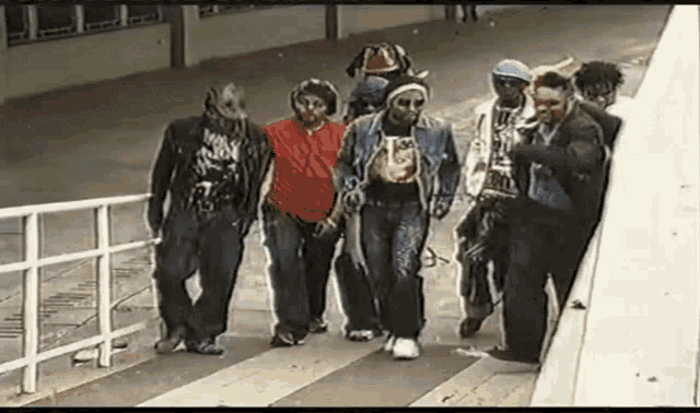 a group of people are walking down a street and one of them is wearing a red shirt that says ' i love you '