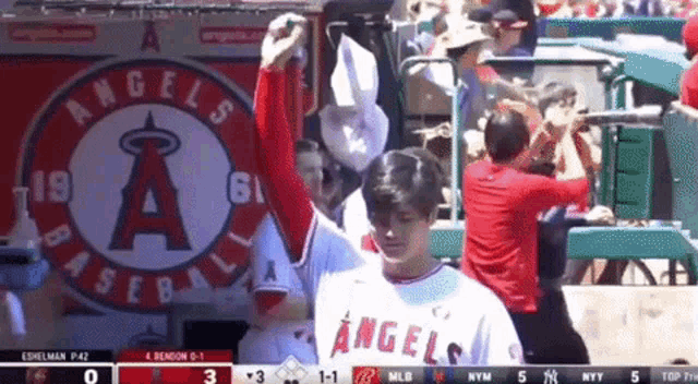 a baseball player for the angels stands in front of a sign that says angels