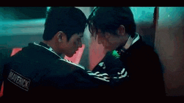 a close up of a man kissing another man on the cheek in a movie .