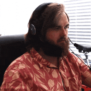 a man with a beard wearing headphones and a red shirt