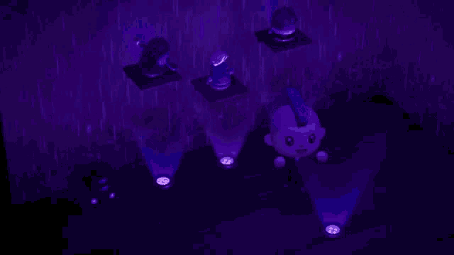a purple light is shining on a statue of a man