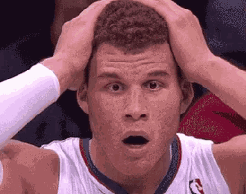 a basketball player has his hands on his head and his mouth open
