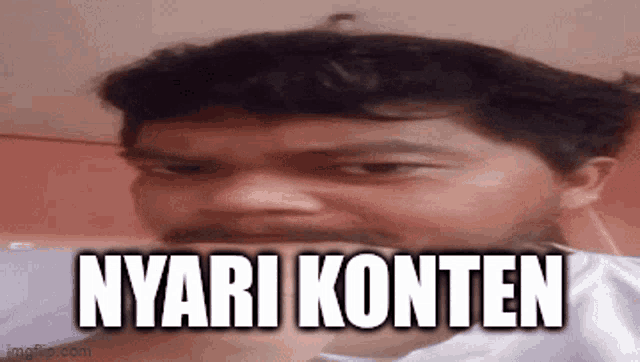 a man with a beard is making a funny face and the words nyari konten are written on his face .