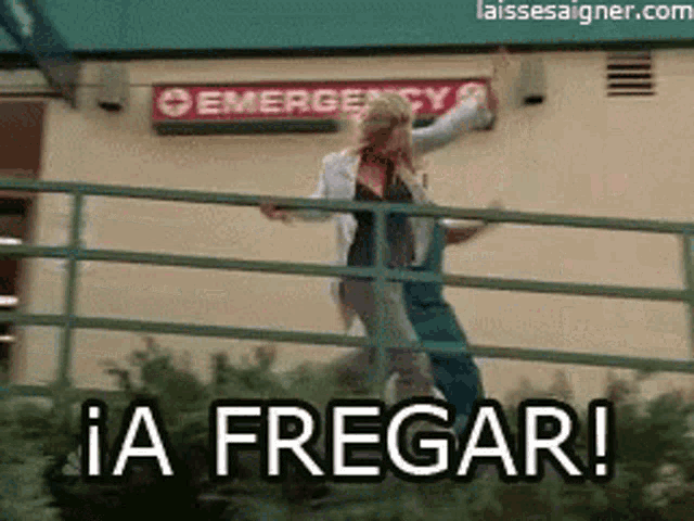 a woman is dancing in front of an emergency room sign .
