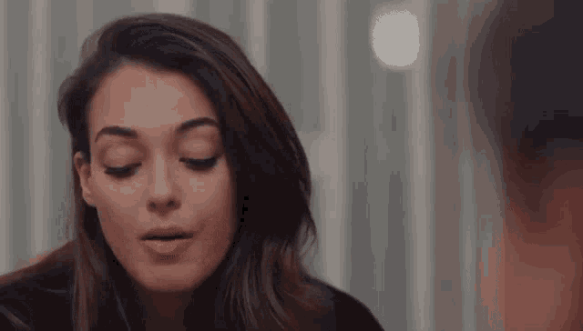 a close up of a woman with her eyes closed .