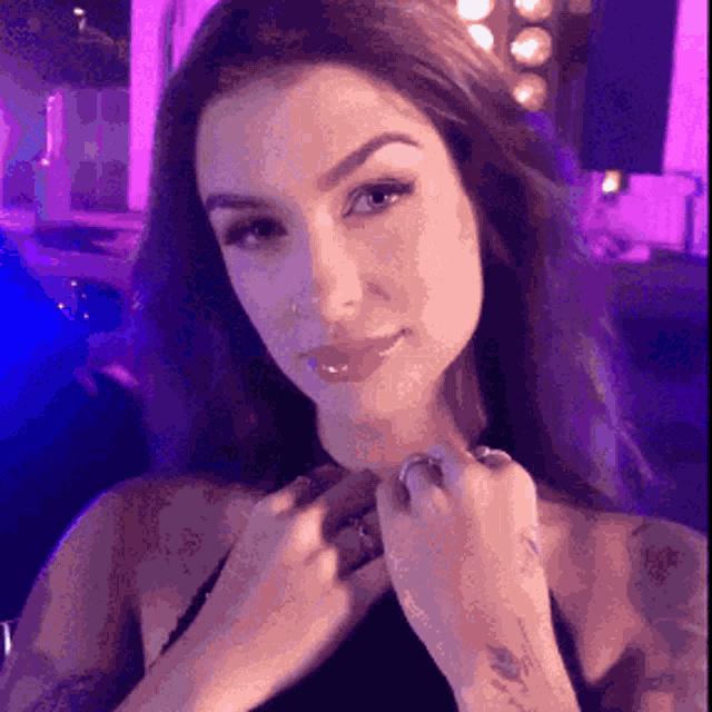 a close up of a woman 's face with a tattoo on her arm