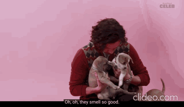 a video of a man holding two puppies with the words oh oh they smell so good at the bottom