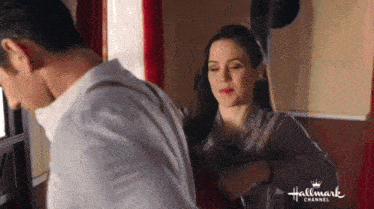 a man and a woman are standing next to each other in a hallmark channel ad .