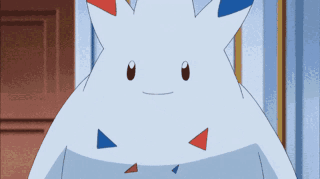 a white cartoon character with red blue and white triangles on it 's body