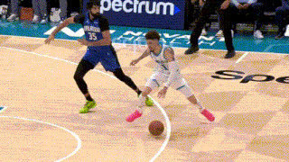 two basketball players on a court with a spectrum ad in the background