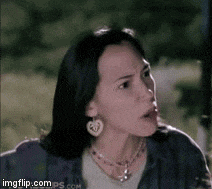 a woman wearing a heart shaped earring and a necklace looks surprised