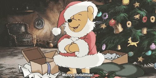 winnie the pooh is dressed as santa claus and standing next to a christmas tree .