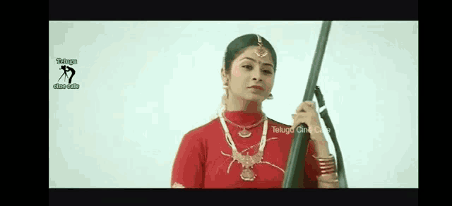 a woman in a red dress is holding a sword in her hand .