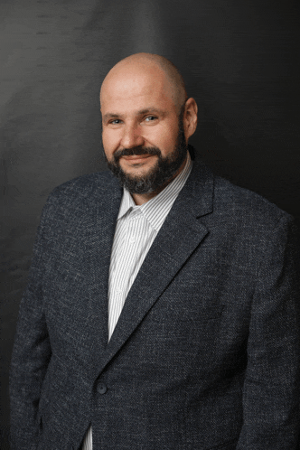 a bald man with a beard wearing a suit