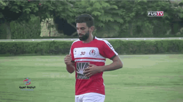 a man in a red and white jersey with the number 30 on the front