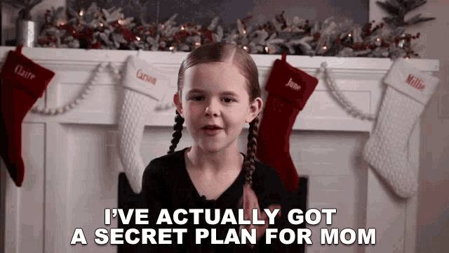 a little girl says i 've actually got a secret plan for mom in front of a fireplace