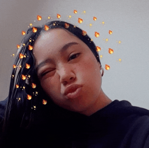 a girl with fire and stars around her head makes a silly face