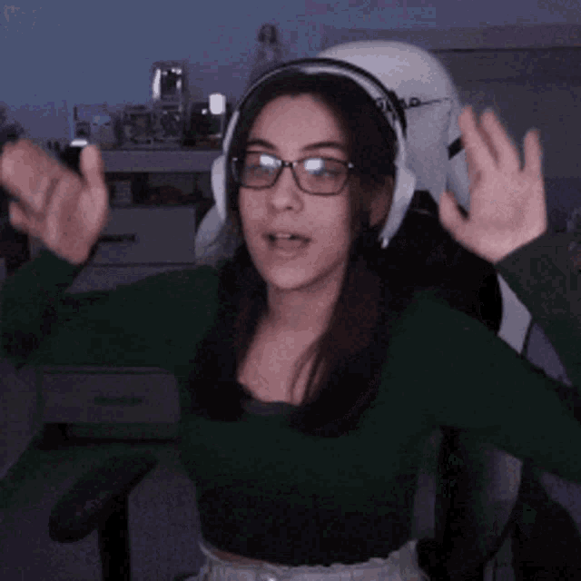 a girl wearing glasses and headphones is sitting in a chair