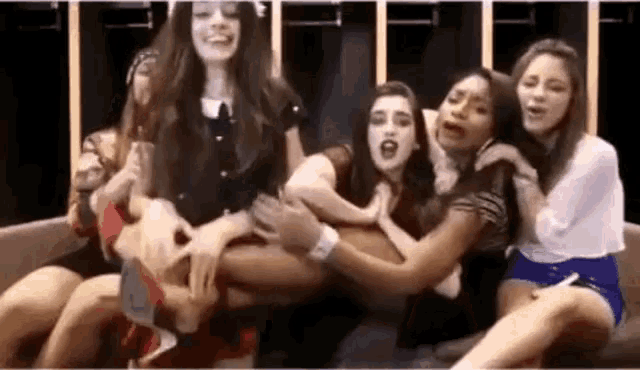 a group of young women are sitting on a couch .