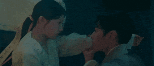 a man and a woman are holding hands and kissing .