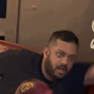 a man with a beard is making a funny face with his mouth open .