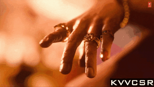 a close up of a person 's hand with rings on their fingers and the words kvvcsr below it