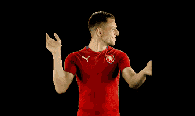 a man in a red shirt with a puma logo on the front