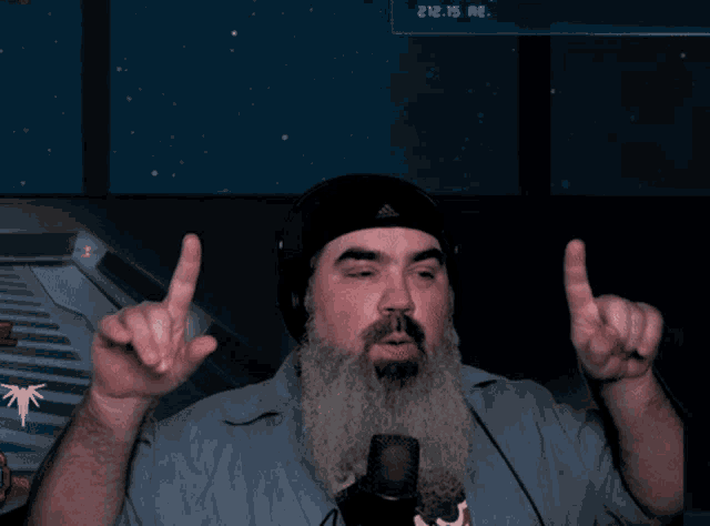 a man with a beard is giving the middle finger in front of a screen that says 2112.15 ae