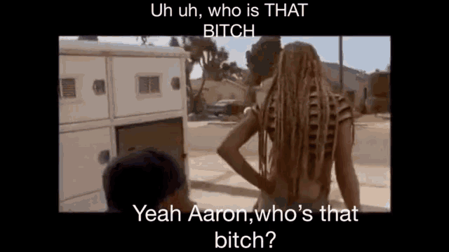a woman with dreadlocks is standing next to a man on a street and talking to him .