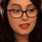 a woman wearing glasses and headphones is looking at the camera and making a funny face .