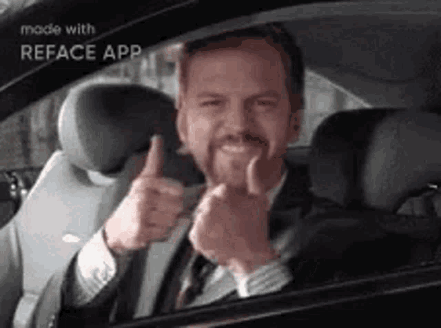 a man in a suit and tie is giving a thumbs up while sitting in the back seat of a car .