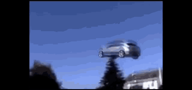 a car is flying through the air on a pole