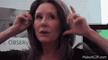 a woman is wearing headphones and making a funny face .