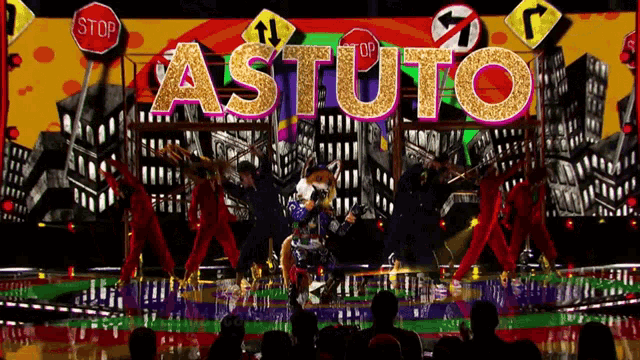 a group of dancers are performing in front of a sign that says astuto