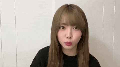 a young woman with long brown hair is making a funny face .