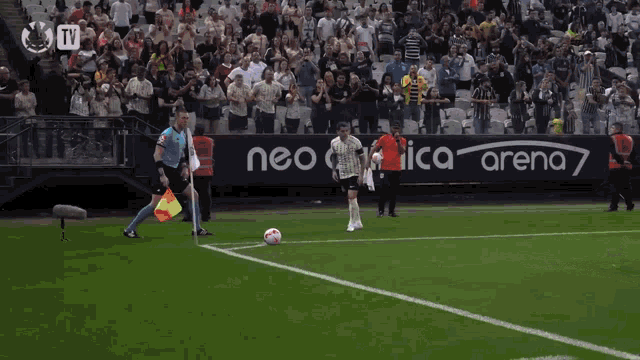 a soccer game is being played in a stadium with a tv advertisement in the background