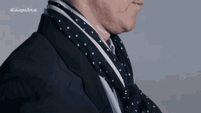 a man is wearing a scarf around his neck and the word esquire is on the bottom right