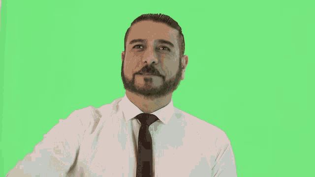 a man with a beard wearing a white shirt and tie pointing at the camera
