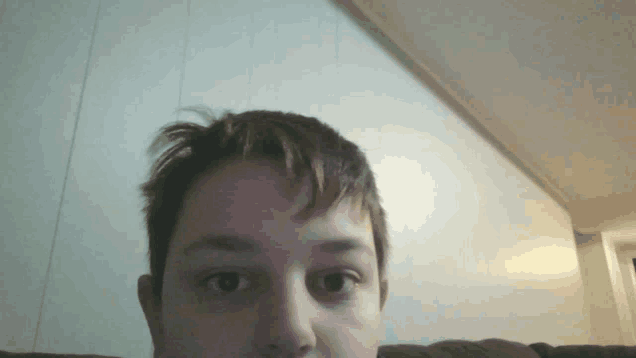 a close up of a person 's face with a white wall behind them