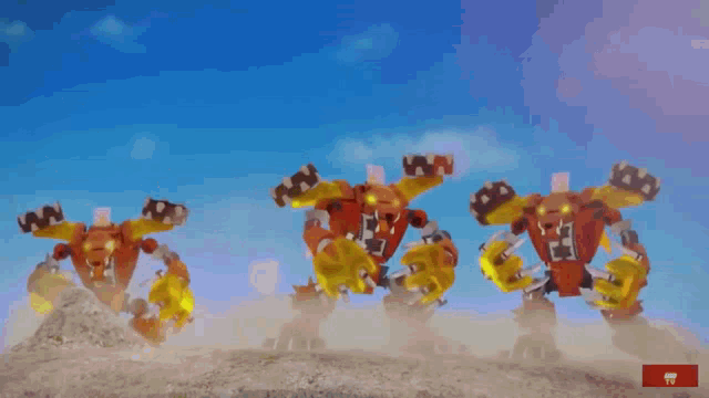 a group of red and yellow robots are standing next to each other with a blue sky in the background