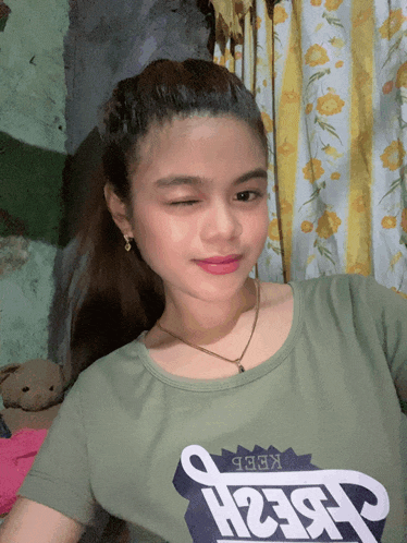 a girl wearing a green shirt with the word keep on it