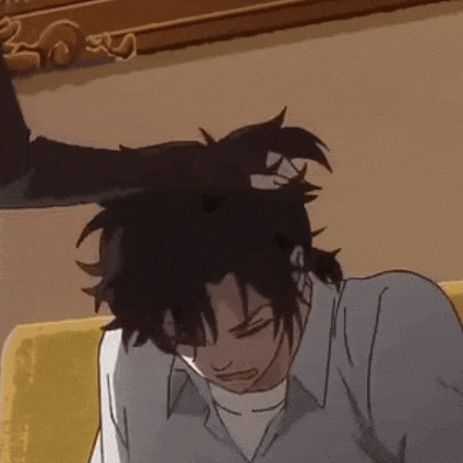 a man is sitting on a couch with his eyes closed while a woman holds his head .