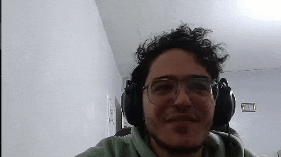a man wearing headphones and glasses is smiling .