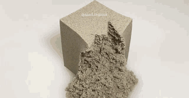 a cube of sand is being cut with a pair of scissors and the words @sand.legious is on the bottom