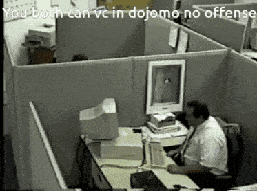 a man sits at a desk in a cubicle with the words you both can vc in dojomo no offense