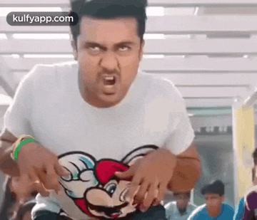a man is wearing a white t-shirt with a mickey mouse on it .