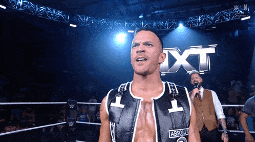 a man in a wrestling ring with a vest that says absolute